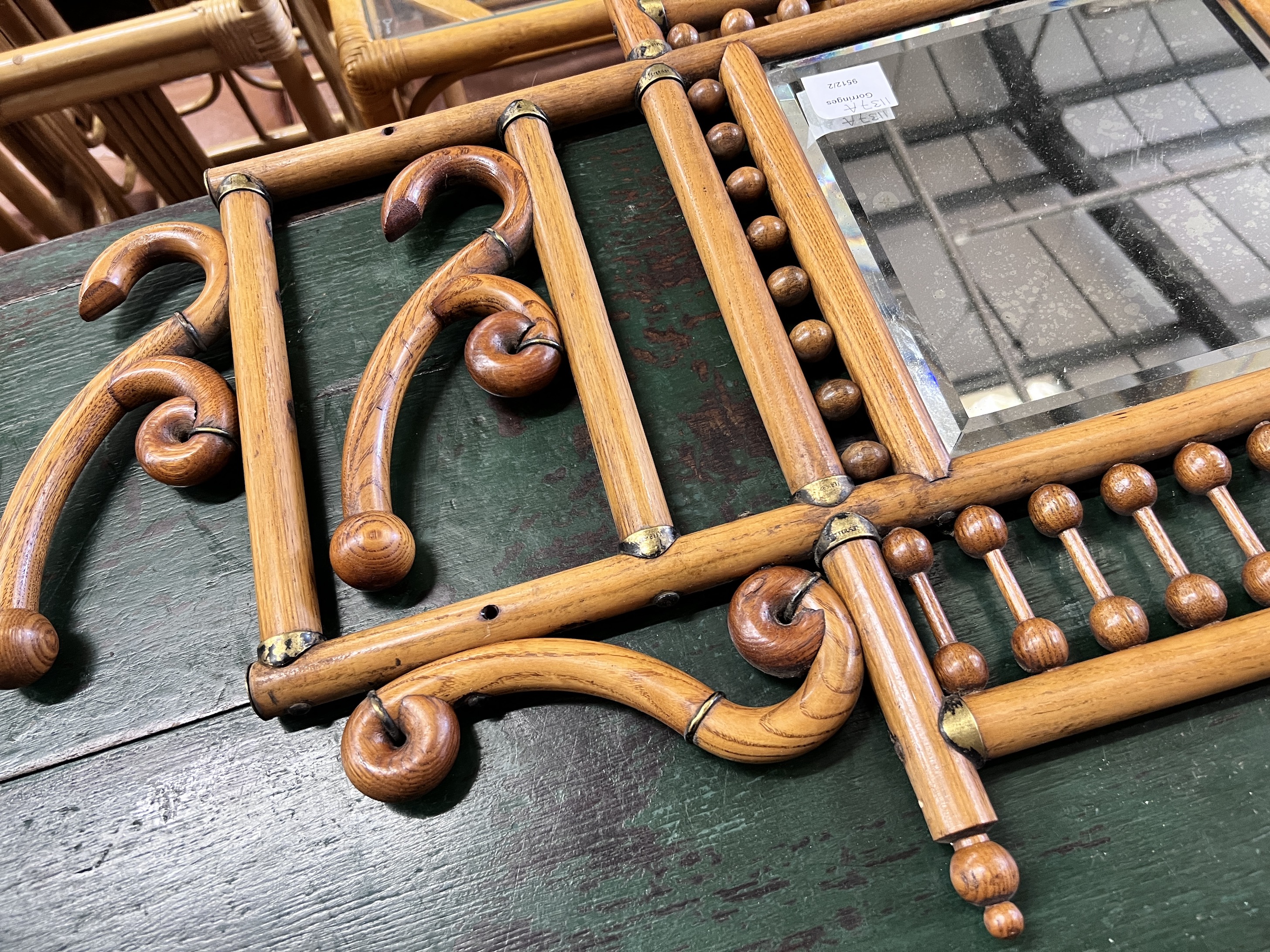 An early 20th century oak and beech mirrored wall hanging coat rack, width 84cm, height 52cm